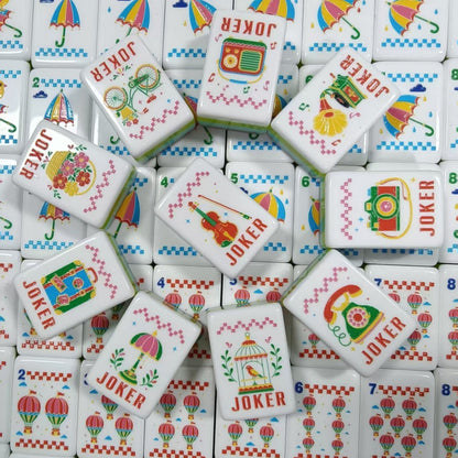 Full layout of Retro Nostalgia American mahjong tiles, ten vintage jokers in first column, N/E/S/W rainbow wind tiles, black cat cracks 1-9, umbrella bamboos 1-9, hot air balloon dots 1-9, butterfly and wreath flower tiles, pink pearlescent backs