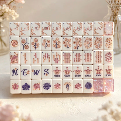 Scattered Blush Crown Floral mahjong tiles flat lay, white tile faces with floral crown artwork, shimmer iridescent blush pink pearlescent backs, peach pink layered sandwich sides, surrounded by soft pink flowers