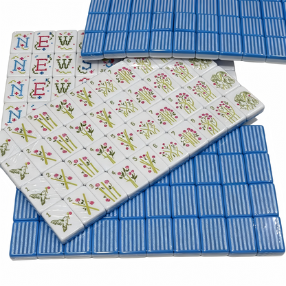 Detailed view of USA Mahjong Co. Sky Linen American Mahjong Set with blue and white striped acrylic tiles and gold inlays.