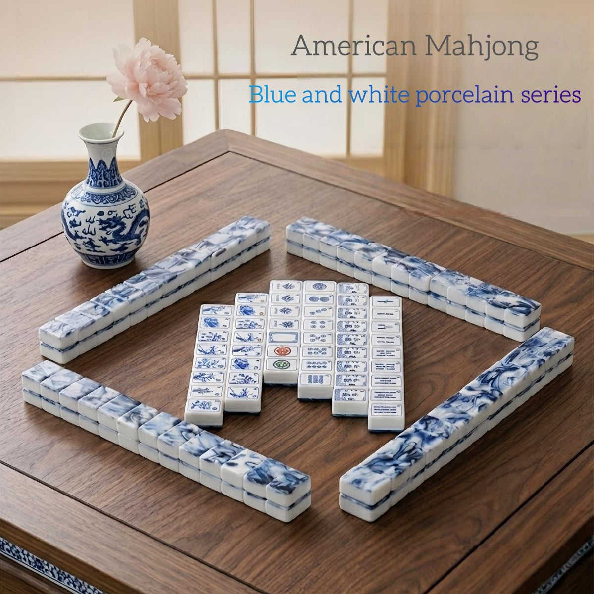 Full layout of blue and white porcelain themed american mahjong tiles arranged on wooden table, chinese porcelain vase decor
