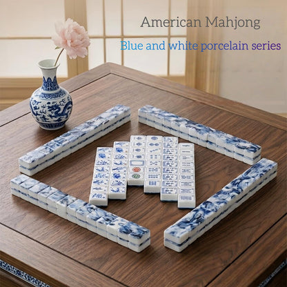 Full layout of blue and white porcelain themed american mahjong tiles arranged on wooden table, chinese porcelain vase decor