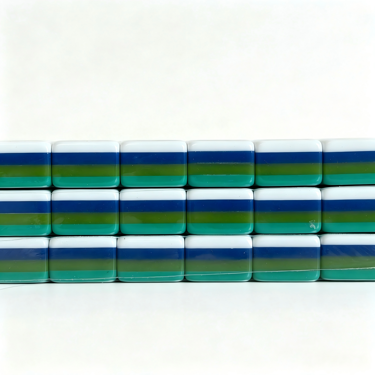 Side profile of teal Lagoon American Mahjong set with 32g weighted tiles, solid teal backs, and monkey jokers by USA Mahjong Co.