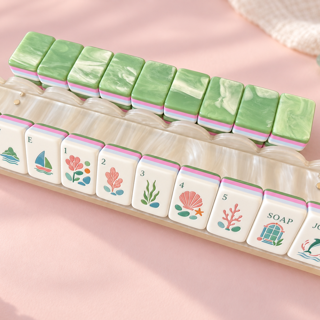 Pile of mixed Coastal Breeze mahjong tiles on water background, showing glossy green swirl marble backs, pastel striped edges, custom nautical art including dolphin jokers, sea turtle dragon, seashell and seaweed patterns